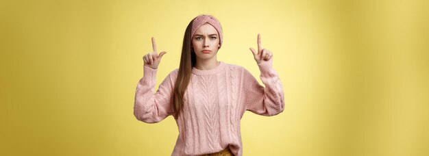 Moody disappointed and upset unamused cute young european girl in knitted warm sweater headband