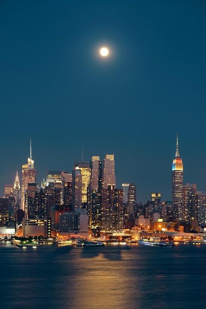 Sorge la luna sopra il centro di manhattan con lo skyline della città di notte