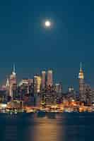 Free photo moon rise over midtown manhattan with city skyline at night