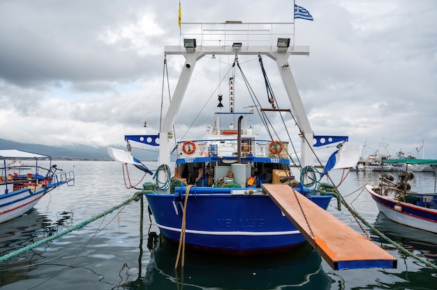 Moored blue and white boat with lowered bridge