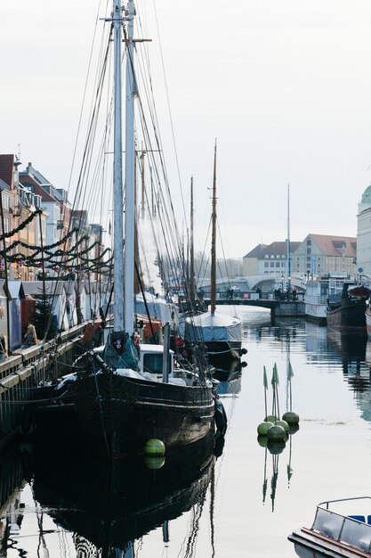 Moored sailboats in channel of city