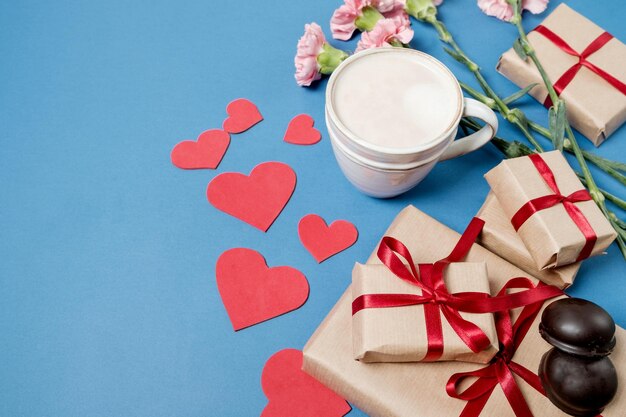 バレンタインデーの朝の朝食コーヒーチョコレート菓子ギフトボックス黄色の背景に紙のハート上面図フラットレイ