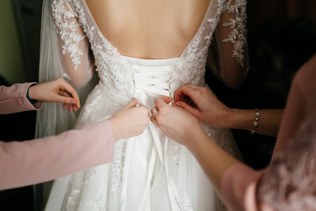 Mattina della sposa quando indossa un bellissimo vestito