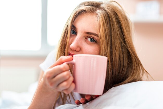 コーヒーのカップを保持している朝の女性