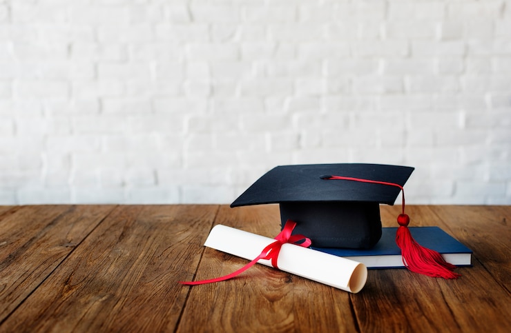 Free Photo mortar board and a graduation diploma