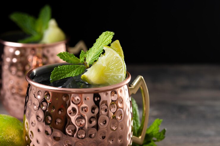 Moscow mule cocktail served with ice and lime slice on wooden table
Kentucky Mule Recipe 2025