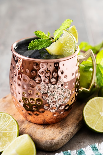 Moscow mule cocktail served with ice and slice of lime on wooden table Copy space