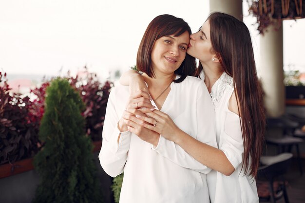 Mother and adult daughter standing in a cite