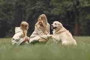 무료 사진 엄마와 강아지와 함께 연주 그녀의 딸입니다. 가을 공원에서 가족. 애완 동물, 가축 및 생활 양식 개념