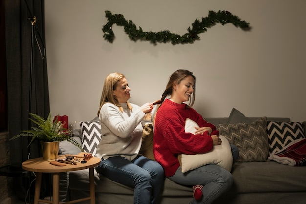 Foto gratuita la madre organizza i capelli delle sue figlie