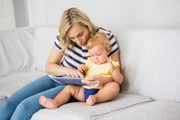 Mother and baby girl using digital tablet