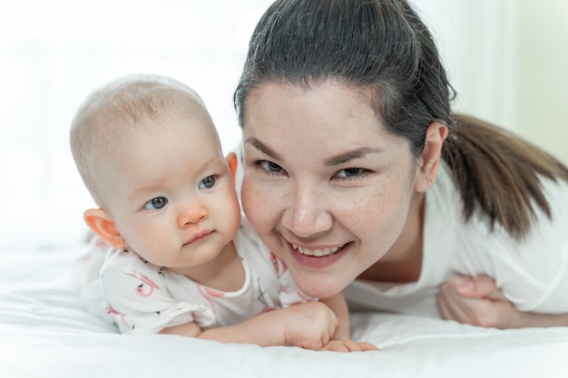 Mother and baby laying in the bed 