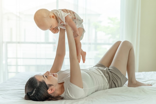 Madre e bambino che giocano nel letto