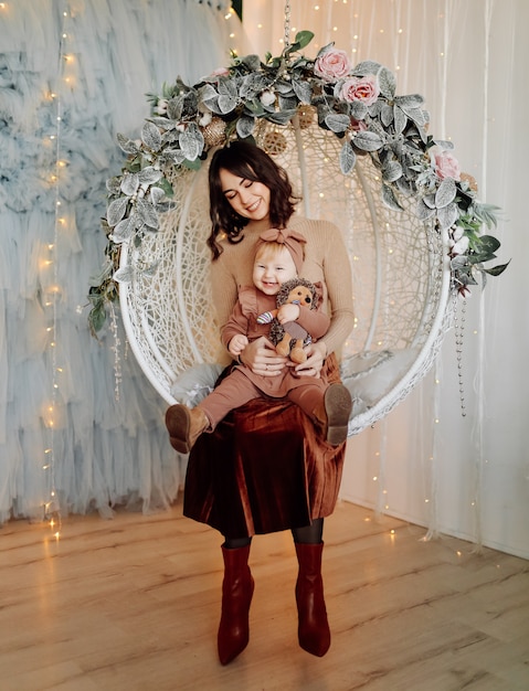 Free photo mother and baby posing in swing