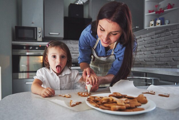 Mother bake with her daughter in the kitchen.