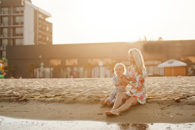 어머니와 해변에서 즐거운 시간을 보내는 아름다운 딸 휴가에 귀여운 소녀와 함께 행복 한 여자의 초상화