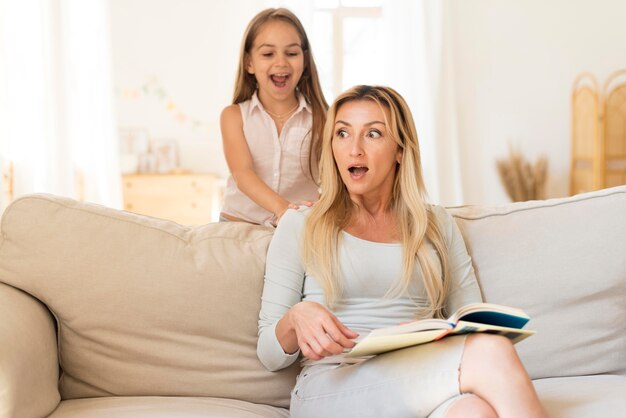 Mother being surprised by daughter sneaking up on her