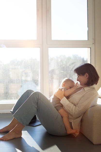 Free photo mother breast feeding her child while working