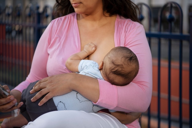 Free photo mother breastfeeding side view