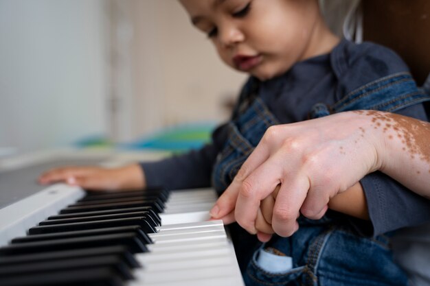 Free photo mother and child playing piano