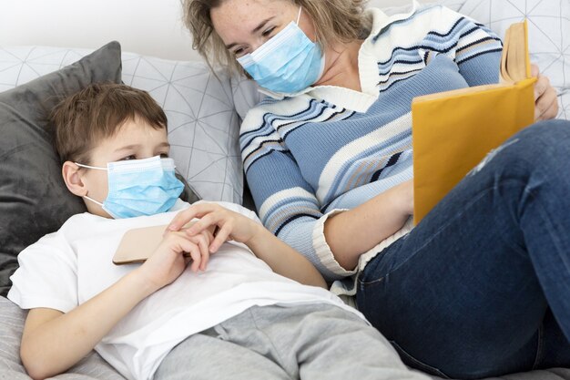 Mother and child wearing medical masks in bed