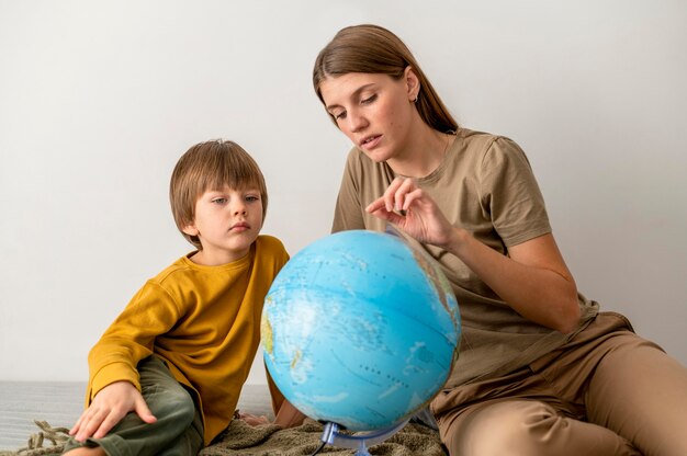 Mother and child with globe at home