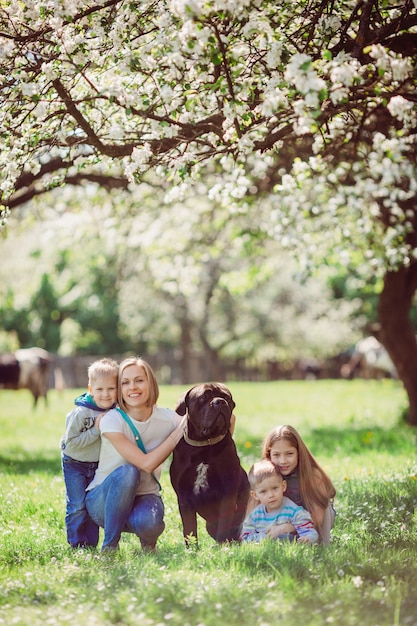 The mother, children and dog sitting on the grass