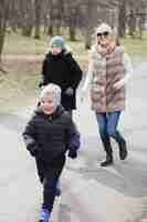 Free photo mother and children in the park on a cold day