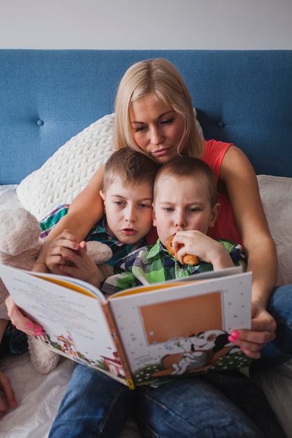 Free photo mother and children reading a book