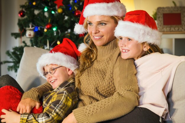 Мать и дети, улыбаясь с Санта шляпы