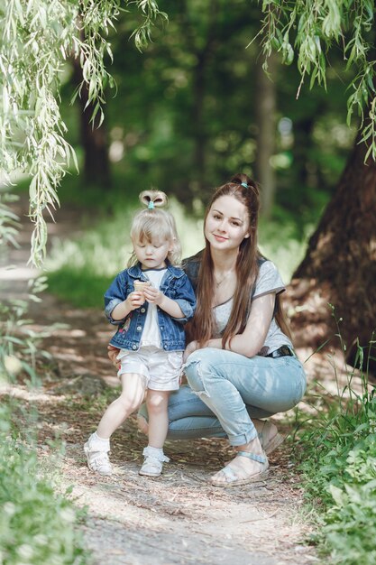 Mother crouching while her daughter eats an ice cream