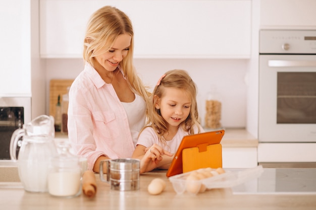 Mother and daughter baking at the kitchen