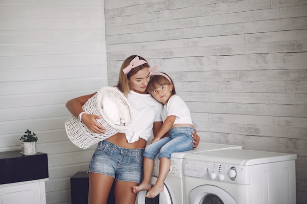 Mother and daughter in a bathroom near wash mashine