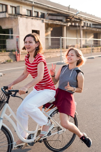 Free photo mother and daughter on a bicycle