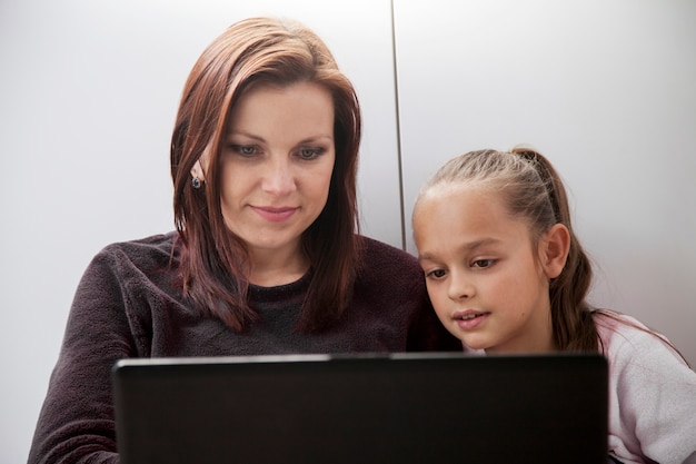 Mother and daughter browsing laptop