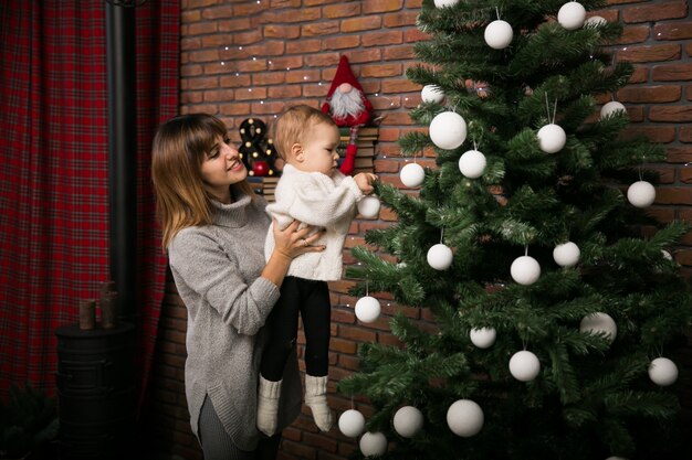 Mother and daughter by the Christmas tree