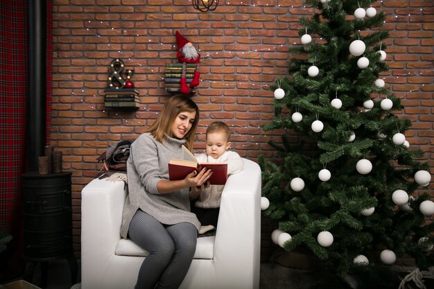 Mother and daughter by the Christmas tree