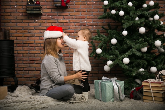 Mother and daughter by the Christmas tree