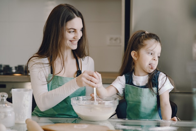 Mother and daughter cook the dough for cookies