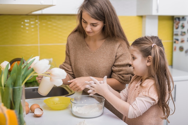 Madre e figlia che cucinano cibo in cucina