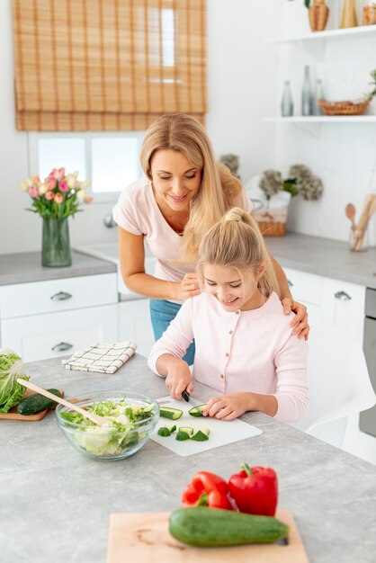 Mother and daughter cutting cucumbers