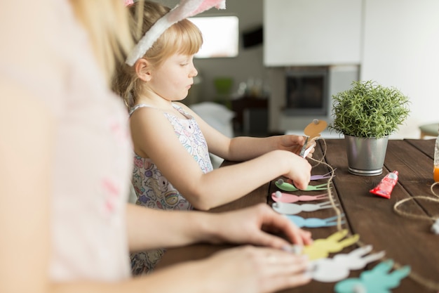 Free photo mother and daughter cutting garland