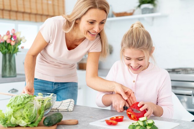 Mother and daughter cutting  peppers