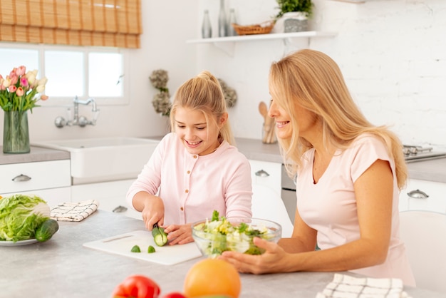 Mother and daughter cutting vegetables together