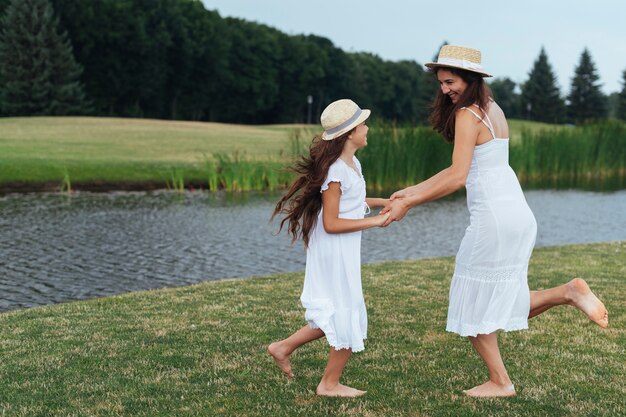 Mother and daughter dancing by the lake