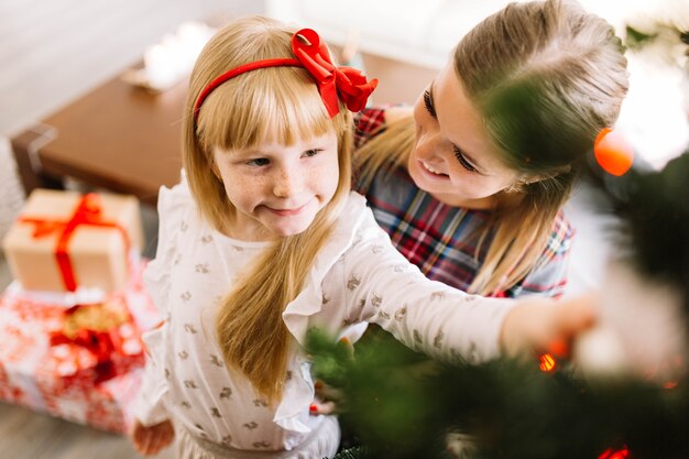 Mother and daughter decorating a christmas tree