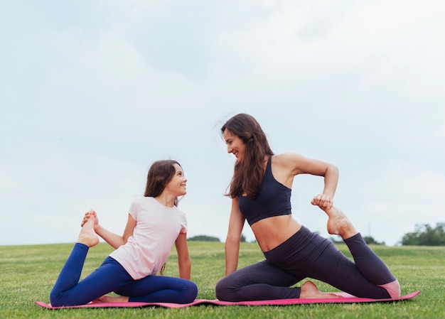 Mother and daughter doing exercises outdoors