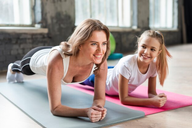 Mother and daughter doing plank on mats