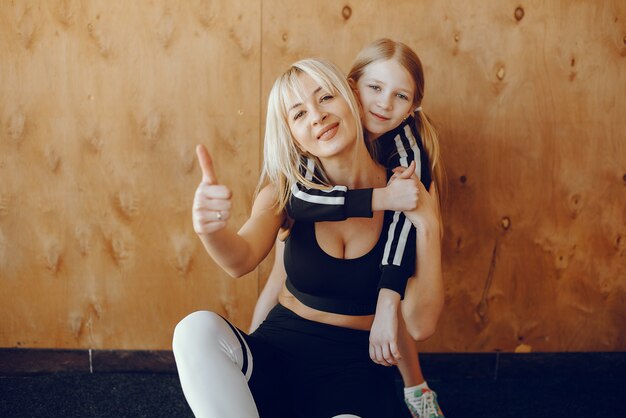 Мать и дочь занимаются йогой в студии йоги