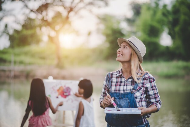 Mother and daughter drawing picture together in the park